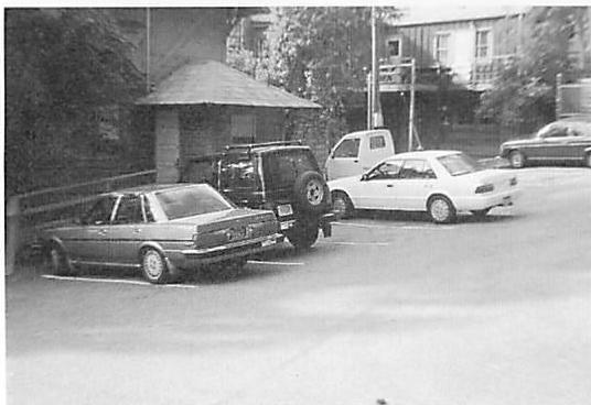 Parking lot with slightly more life. Cars are placed in irregular ways, the small building enters the space and creates more relationship