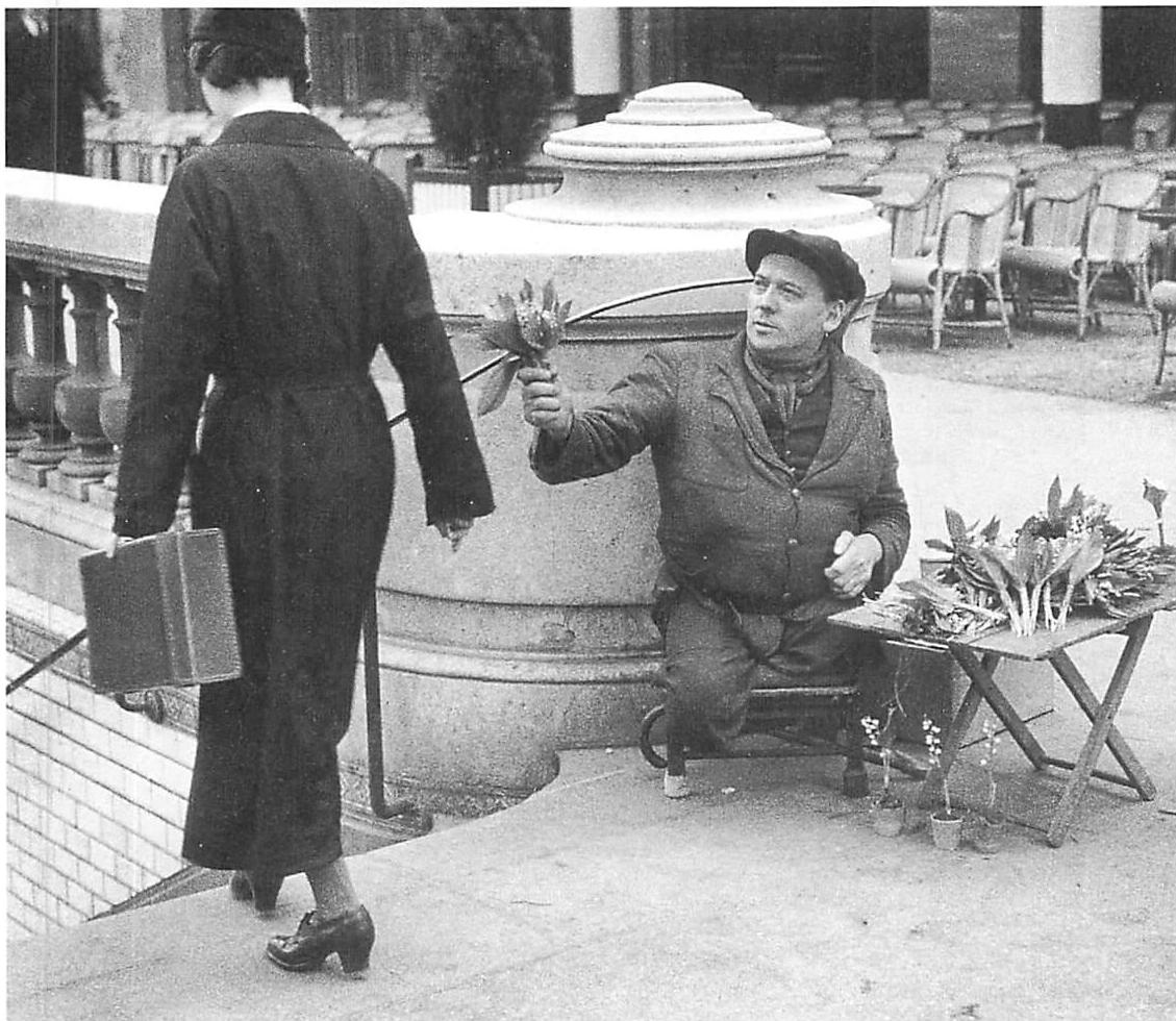 The girl ignores the flower seller without legs