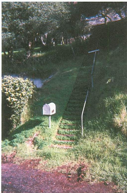 Mailbox which is structure-preserving. The landscape, steps, grass, and their wholeness are preserved by the insertion of the mailbox.