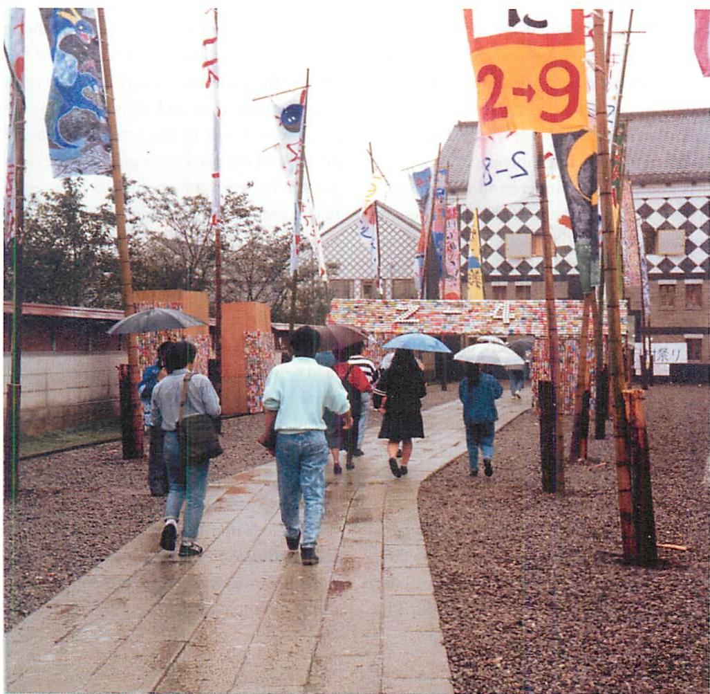 In the rain on the Eishin campus, students hurrying from class to class. Christopher Alexander, 1985