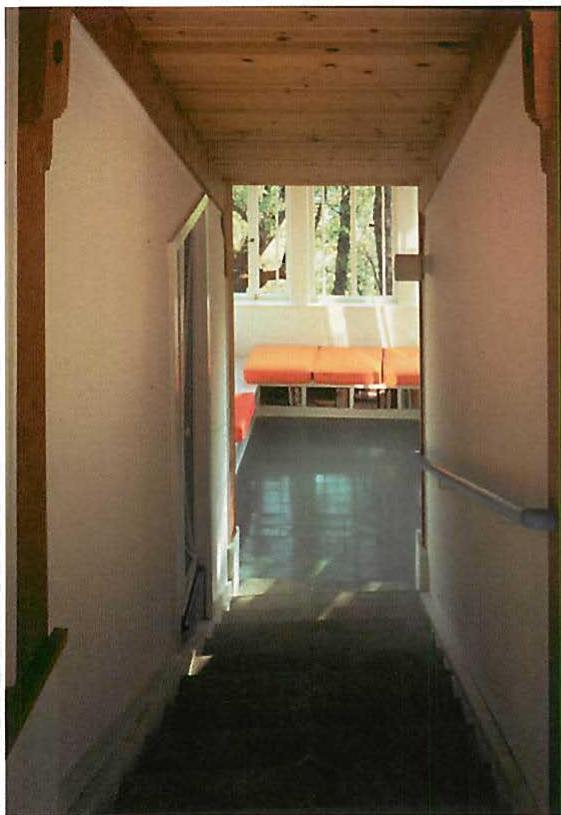 Left: stair down to library. Right: the main stair with sunlight shining through diamond-shaped openings in the wall