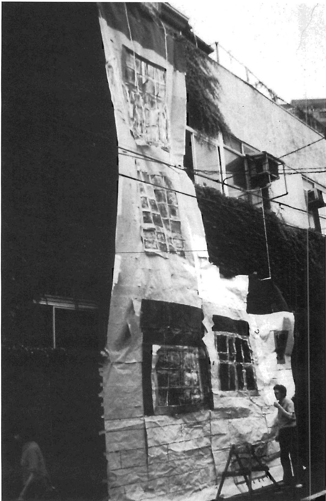 Emato building. Tokyo. The picture shows Hajo Neis making a fullsize mockup in painted paper on the building that existed previously on the site, to study the effect of the elevation design and materials on the street, so that we could make sure that the street was helped by the building