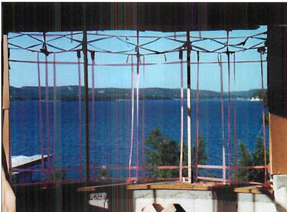 Mockup we did to get the pattern of glazing bars for the windows in the dining room. We adjusted the tapes you see in this photograph, until they formed a beautiful pattern and enhanced the lake. Then we had the windows built. Christopher Alexander, Randy Schmidt, 1996.