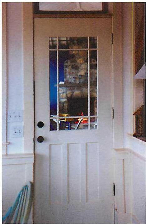 The outdoor fireplace on the porch, seen through a window in the dining-room door.