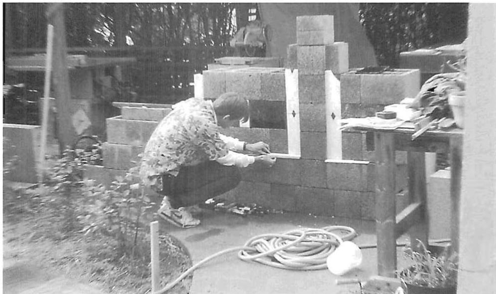 Massive stones being checked for the Hodgson house, California. The stones are cast concrete. Each one has a dark surface; the surface is cast, then washed with a light water wash. Inset, or inlaid next to the stone, is a chase to receive a fine line of white marble.
