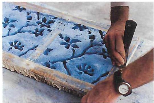 Left: Blue terrazzo in place, white not yet troweled in. Right: Cleaning a tile. The completed floor is shown on page 585.