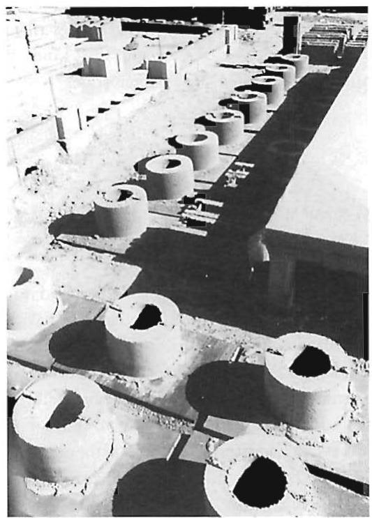 Left: Special blocks for the Mexicali project as we manufactured them. The design of these cylindrical blocks allowed round columns to be made, both beautiful in design and easy and cheap to make, thus allowing “making” to go on rather easily. Right: Two of the special molds we made for fabricating blocks. In the illustration on page 551, the protruding reinforcing steel is clearly visible coming out of the side of each foundation block.