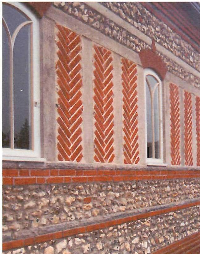 The north wall: windows, herringbone-brick panels, flint.