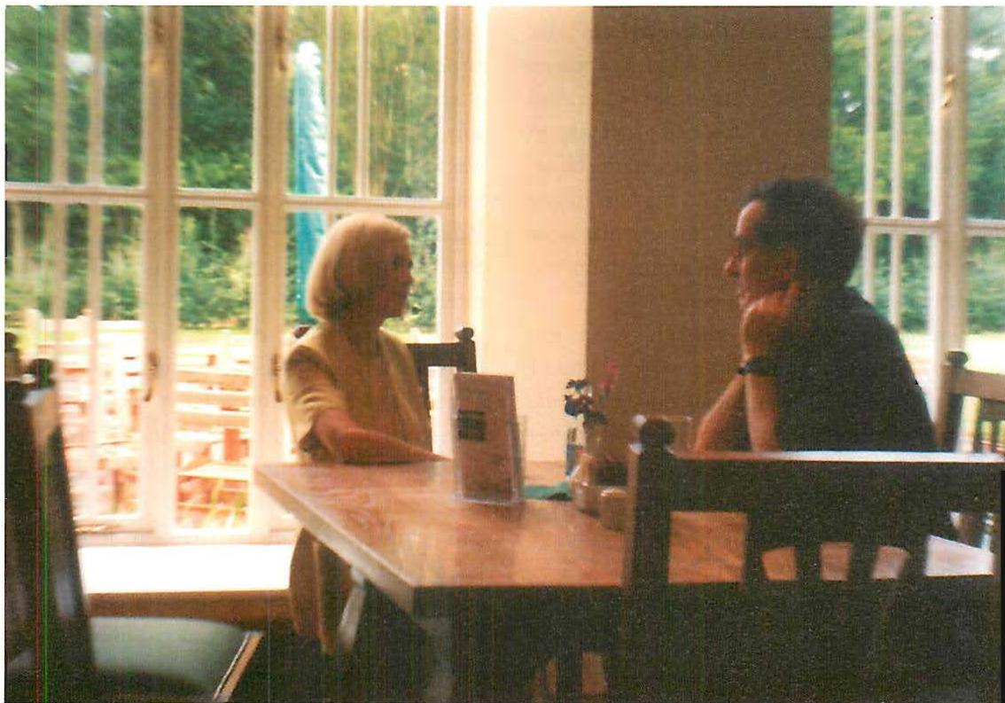 Two people at ease in the dining room, on a rainy day.